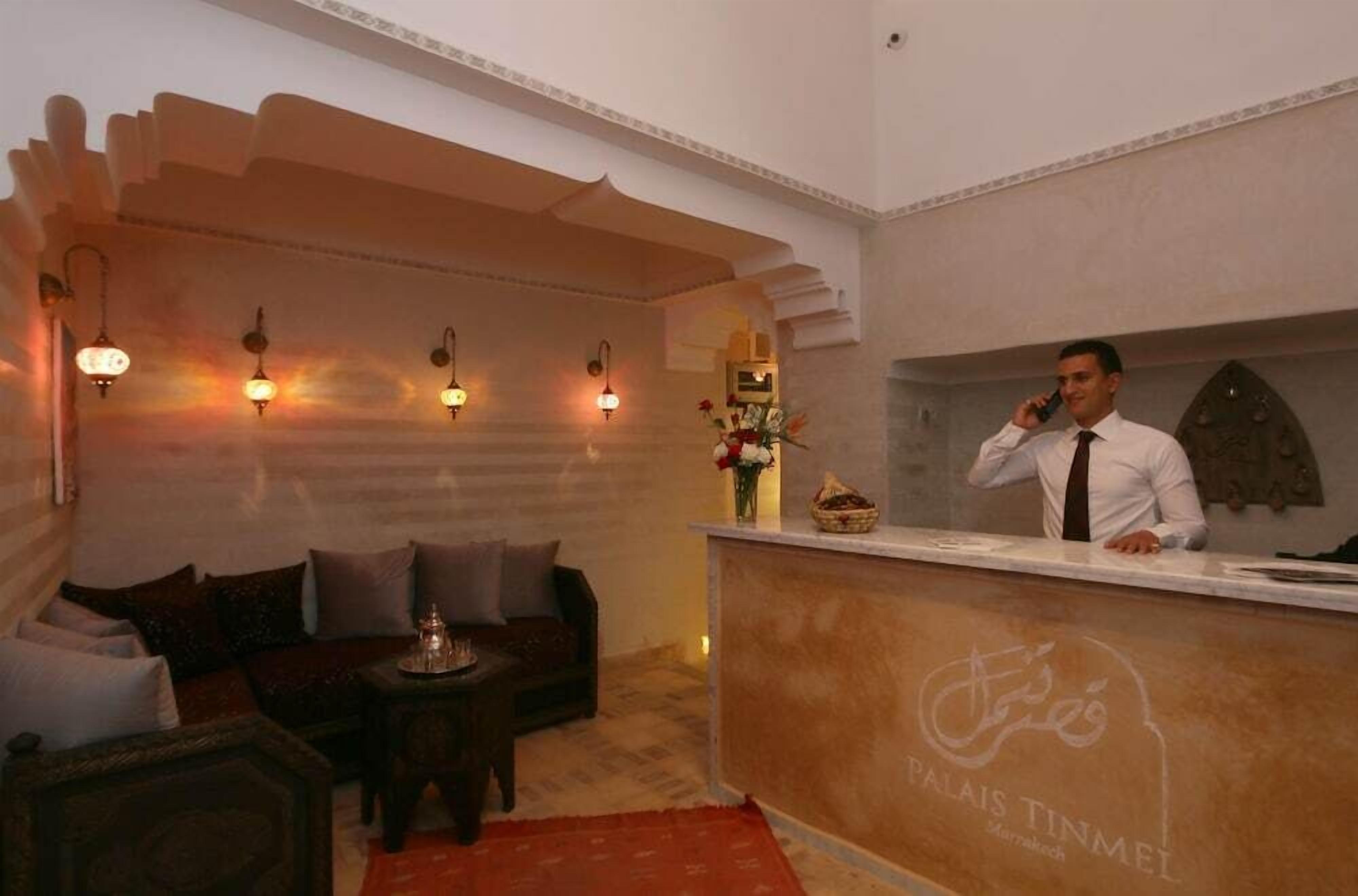 A reception area with a counter, a sofa, and a decorative wall.