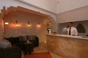 A reception area with a counter, a sofa, and a decorative wall.
