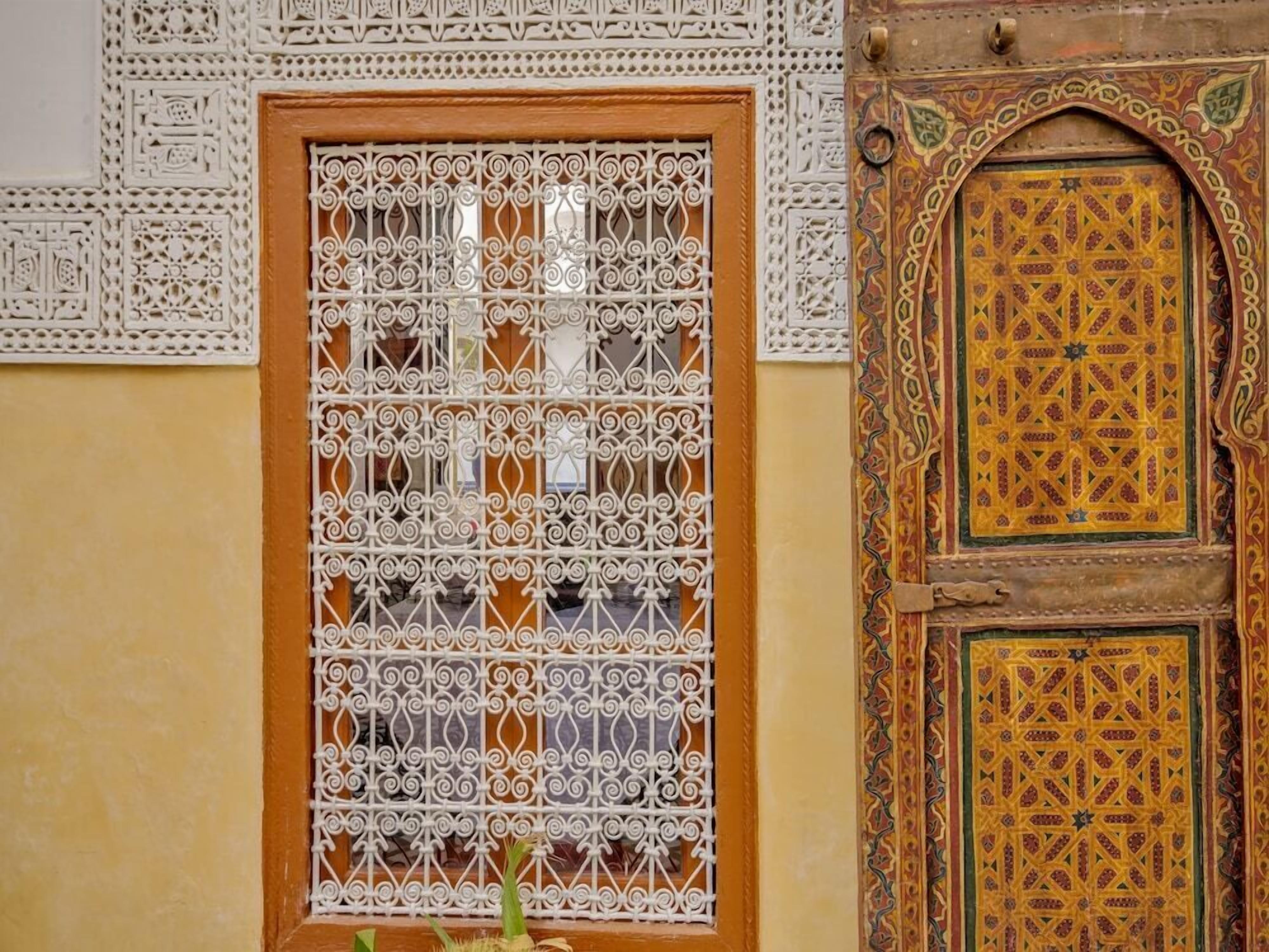 A door with intricate metal lattice and a decorative panel with geometric patterns.