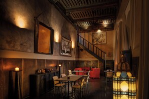 A restaurant with a staircase, wooden beams, and a lantern.