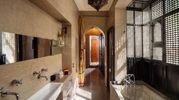 Un bagno moderno con una vasca da bagno ampia, una zona doccia separata e un mobile lavabo con specchio.