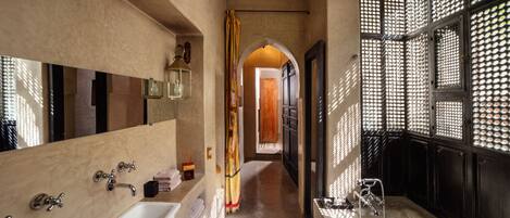 Une salle de bain moderne dotée d’une grande baignoire, d’une douche séparée et d’un meuble-lavabo avec un miroir.