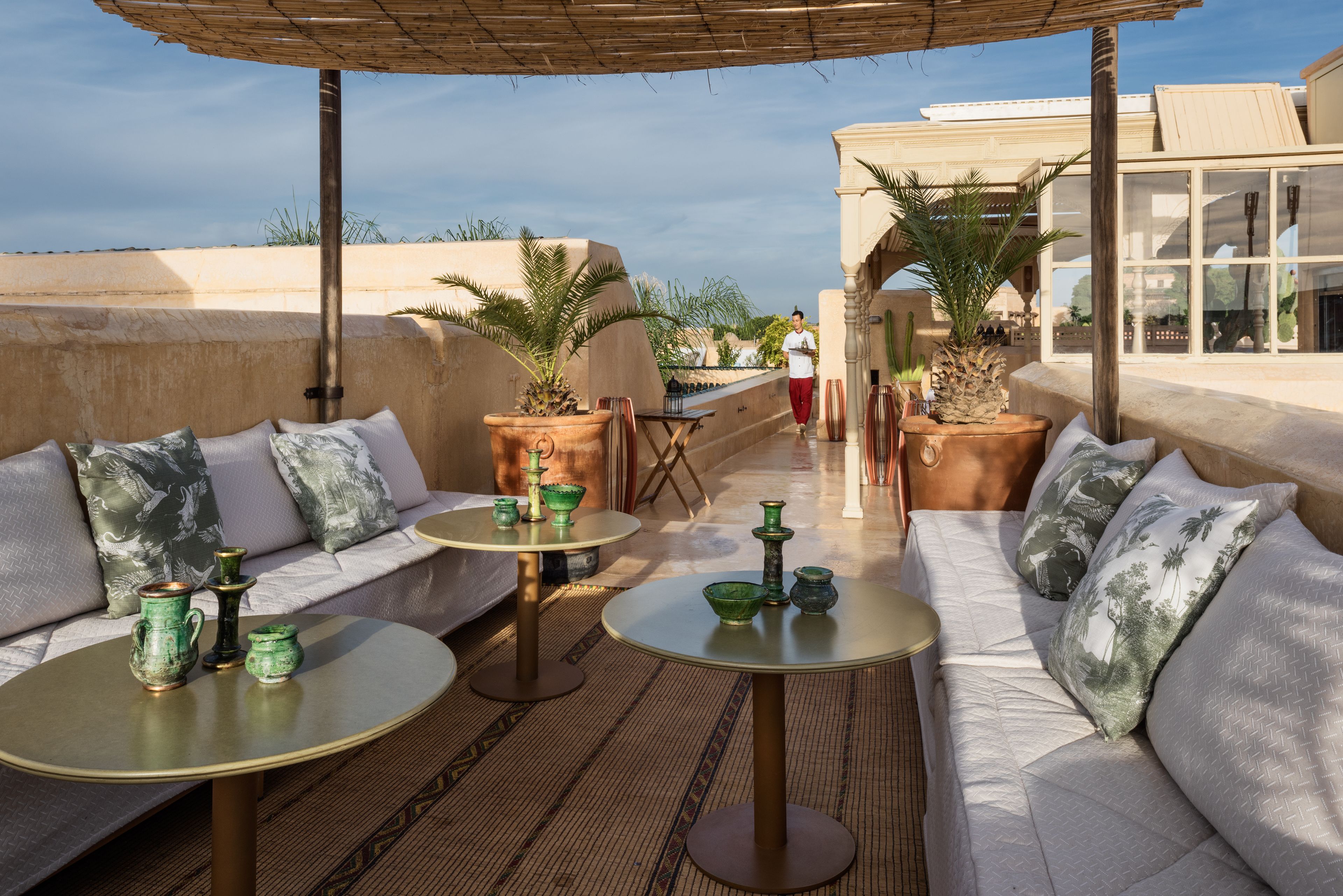 Una terrazza sul tetto con posti a sedere all'aperto, tavoli e decorazioni.