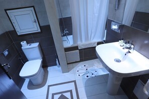 A modern bathroom with a toilet, sink, and shower area. - Helnan Chellah Hotel (Rabat)