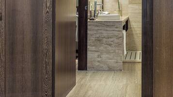 Un baño moderno con tocador de madera, un lavamanos y un espejo.