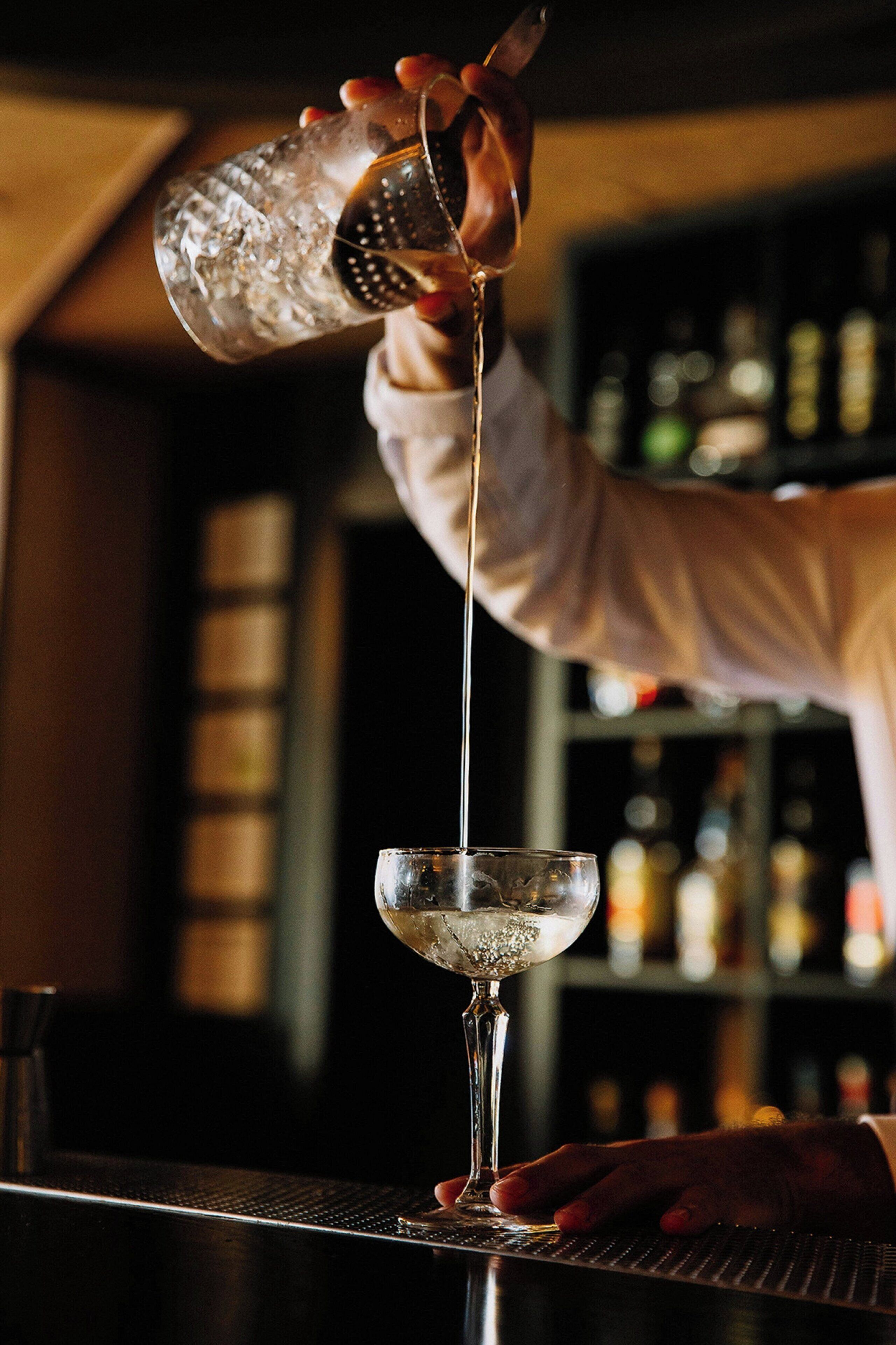 Un barman verse une boisson dans un verre.