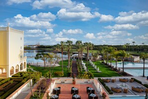 A resort with a pool, outdoor seating, and a view of the water.