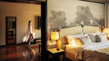 Une chambre d’hôtel avec un grand lit, une table de chevet, une lampe et un mur orné d’un grand tableau abstrait.