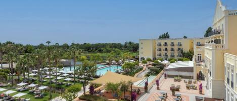 A resort with a pool, outdoor seating, and manicured gardens.
