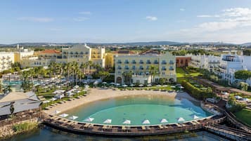 Ein Resort mit großem Pool, mehreren Gebäuden und Strandabschnitt.