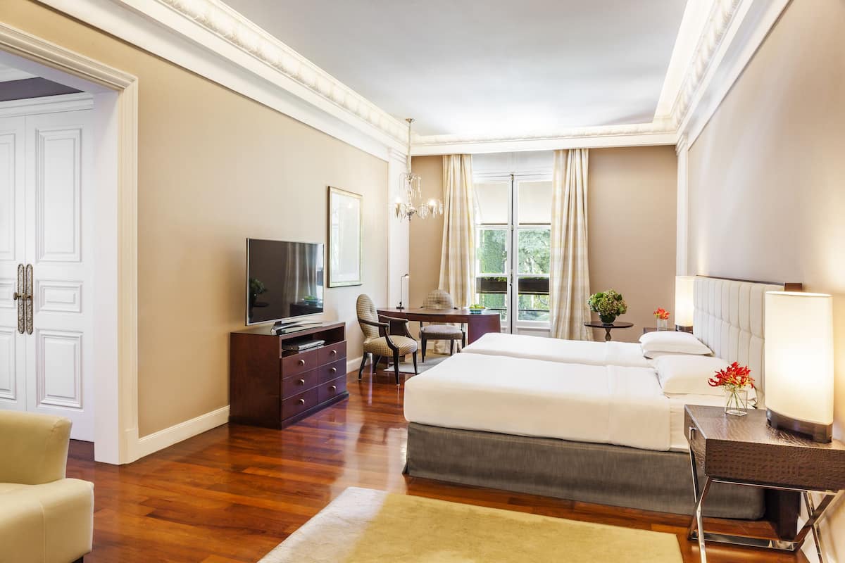 Une chambre d’hôtel avec un grand lit, un bureau, une télévision et une vue sur l’extérieur.