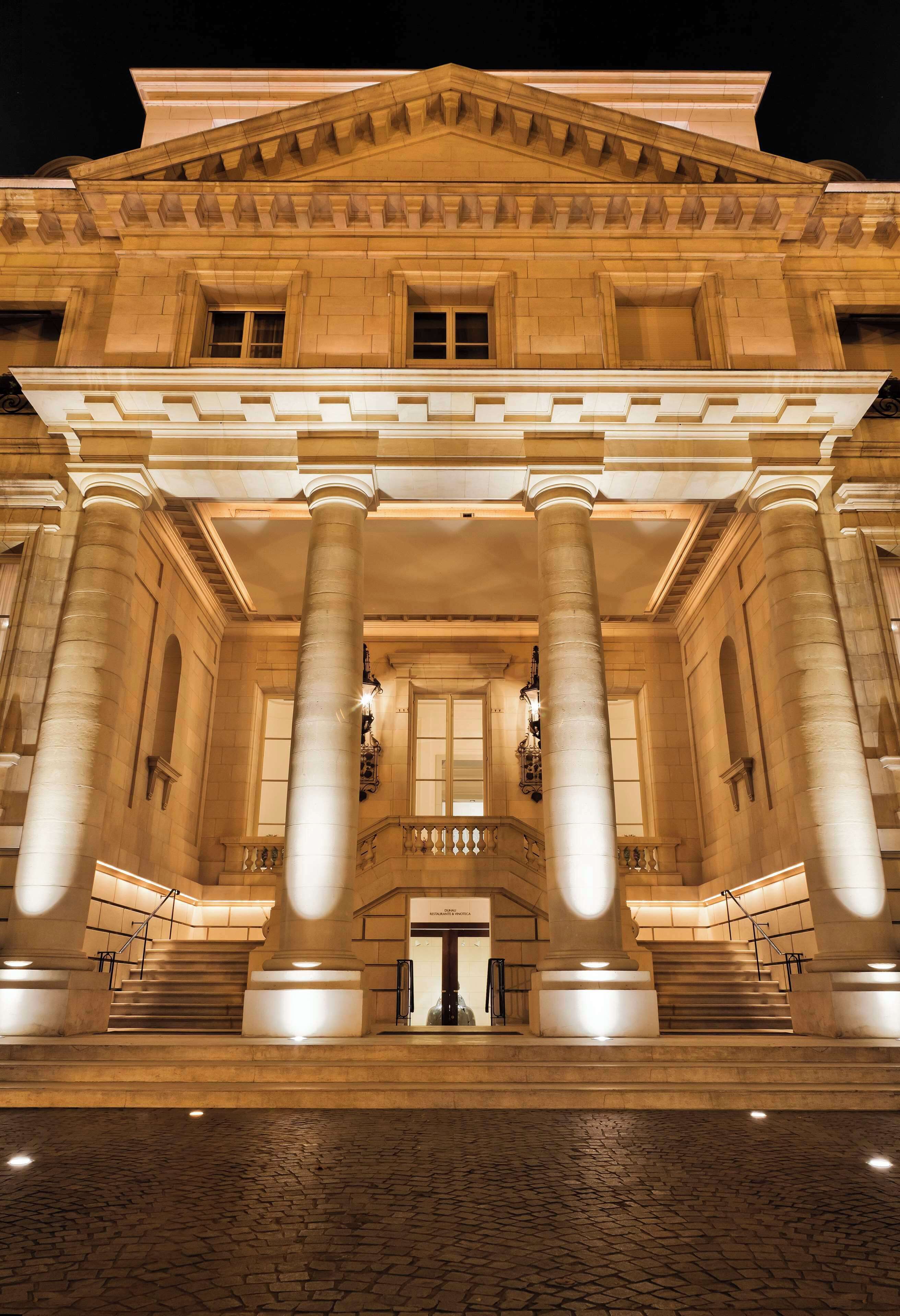 A grand building with large columns, a central staircase, and a symmetrical facade.