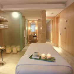 Relax in a serene space with a large bed, candles, and a soothing ambiance.