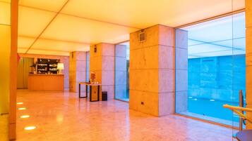 A spacious lobby with a reception desk, a seating area, and large windows offering a view of the interior.