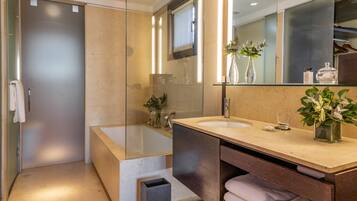 Une salle de bain moderne avec une douche à parois de verre, une grande baignoire et un meuble-lavabo avec un miroir.
