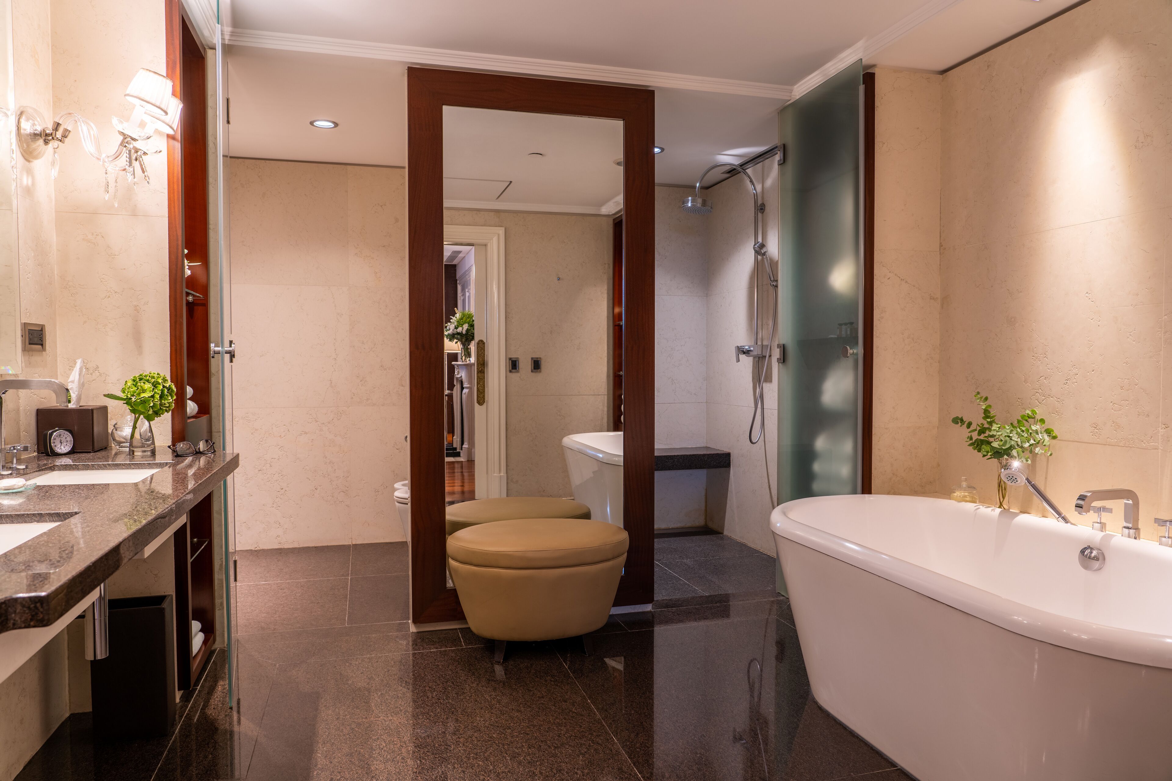 A modern bathroom with a freestanding bathtub, a vanity with a mirror, and a toilet.