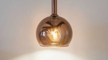 A pendant light fixture with a spherical glass shade and a visible bulb.