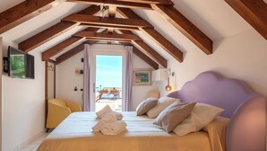 Une chambre à coucher avec un lit, des oreillers, une chaise et une fenêtre avec des rideaux.