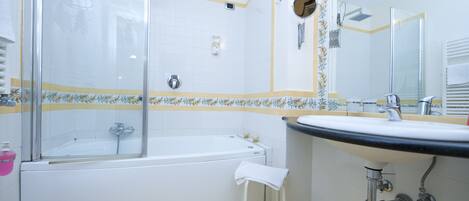 Ein Badezimmer mit Badewanne, Waschbecken und Duschbereich.