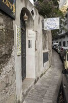 A narrow street with a building featuring a sign for "Villa Relais Innalaro."