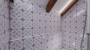 A bathroom with purple and white patterned tiles, wooden beams, and a shower area.