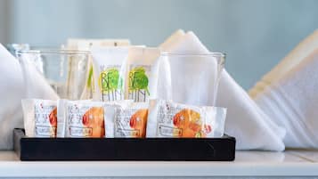 Una bandeja con productos de limpieza y un vaso de agua sobre una superficie de mármol.