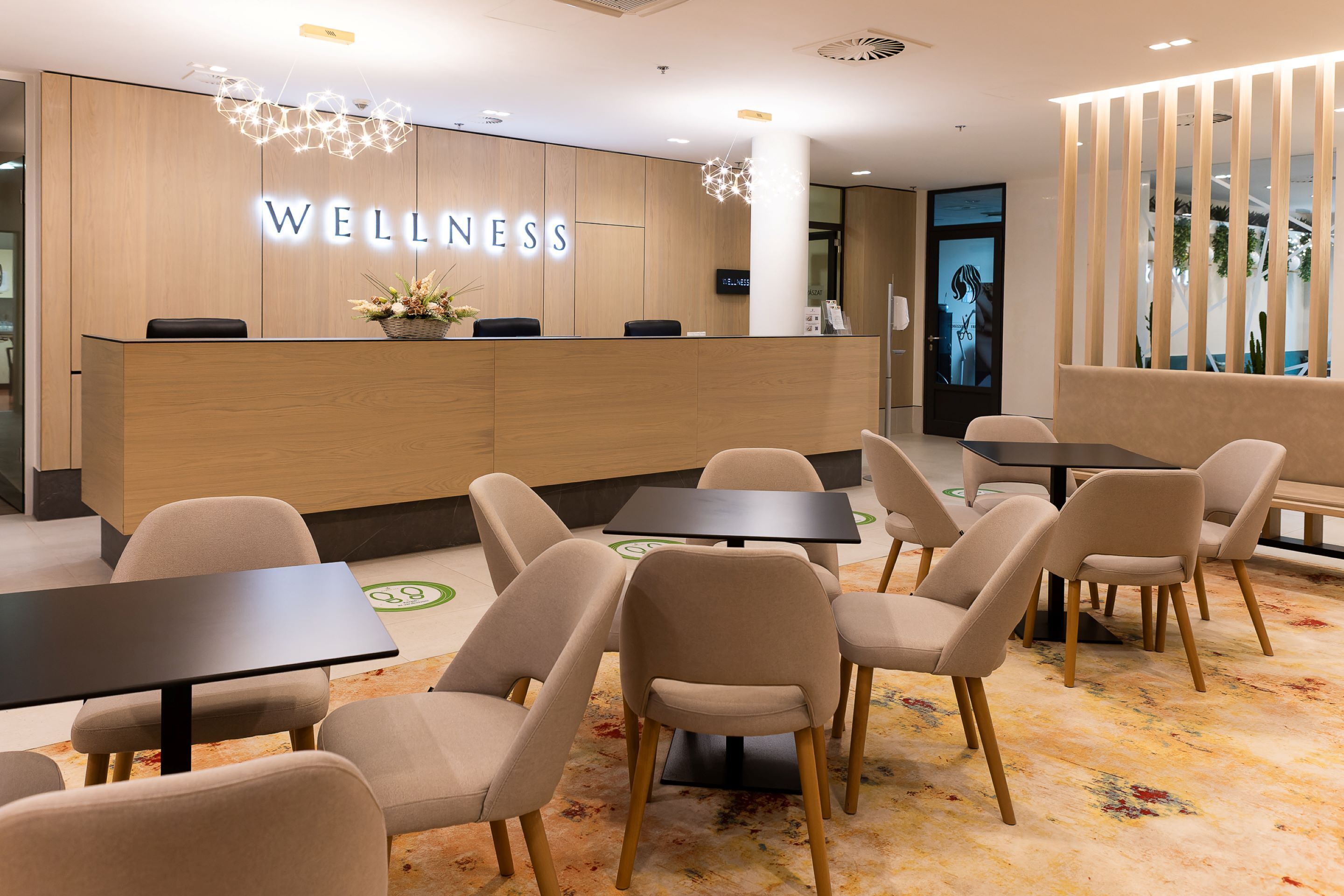 A modern wellness center with a reception desk, seating area, and a large screen displaying a woman.