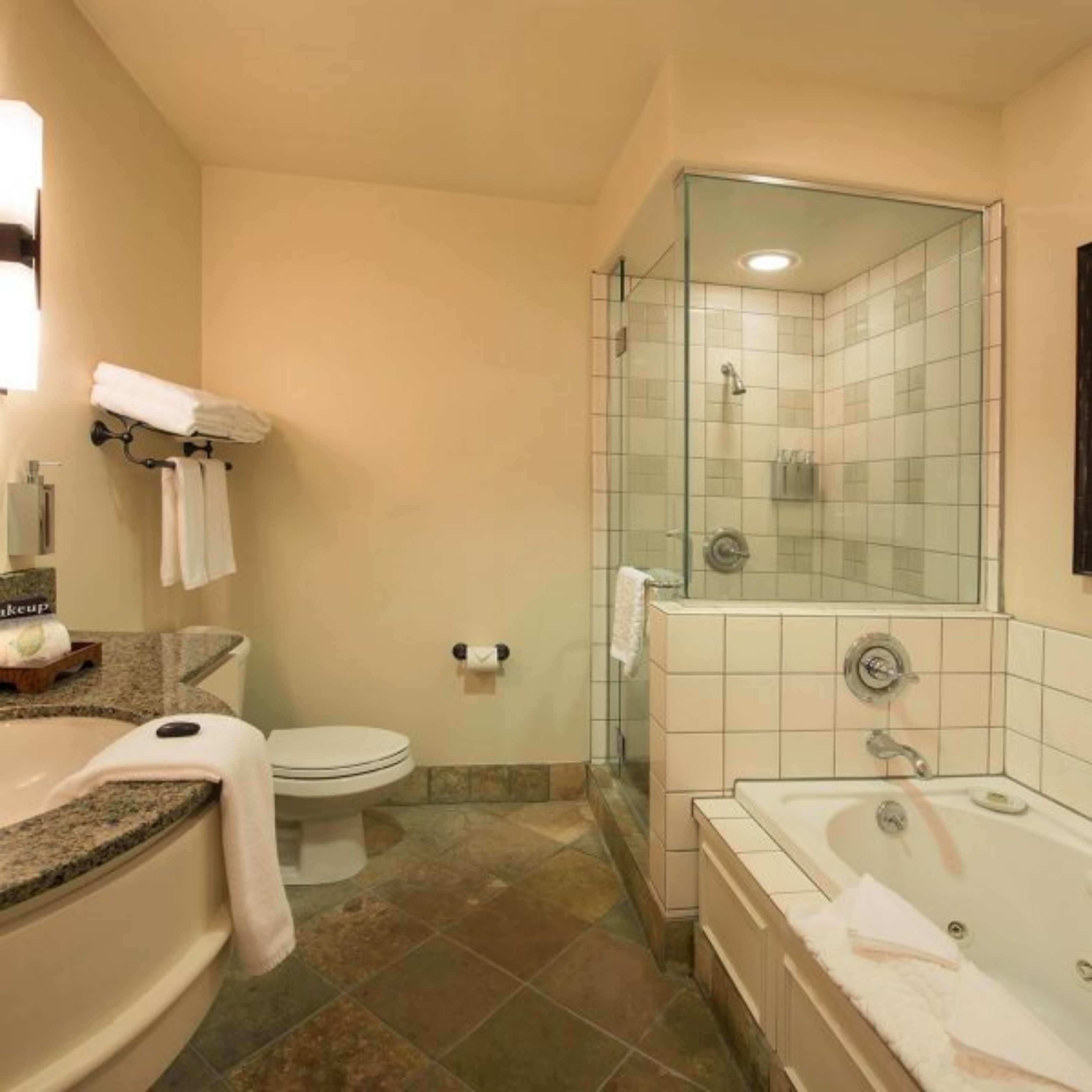 A bathroom with a toilet, a sink, a bathtub, and a shower area.
