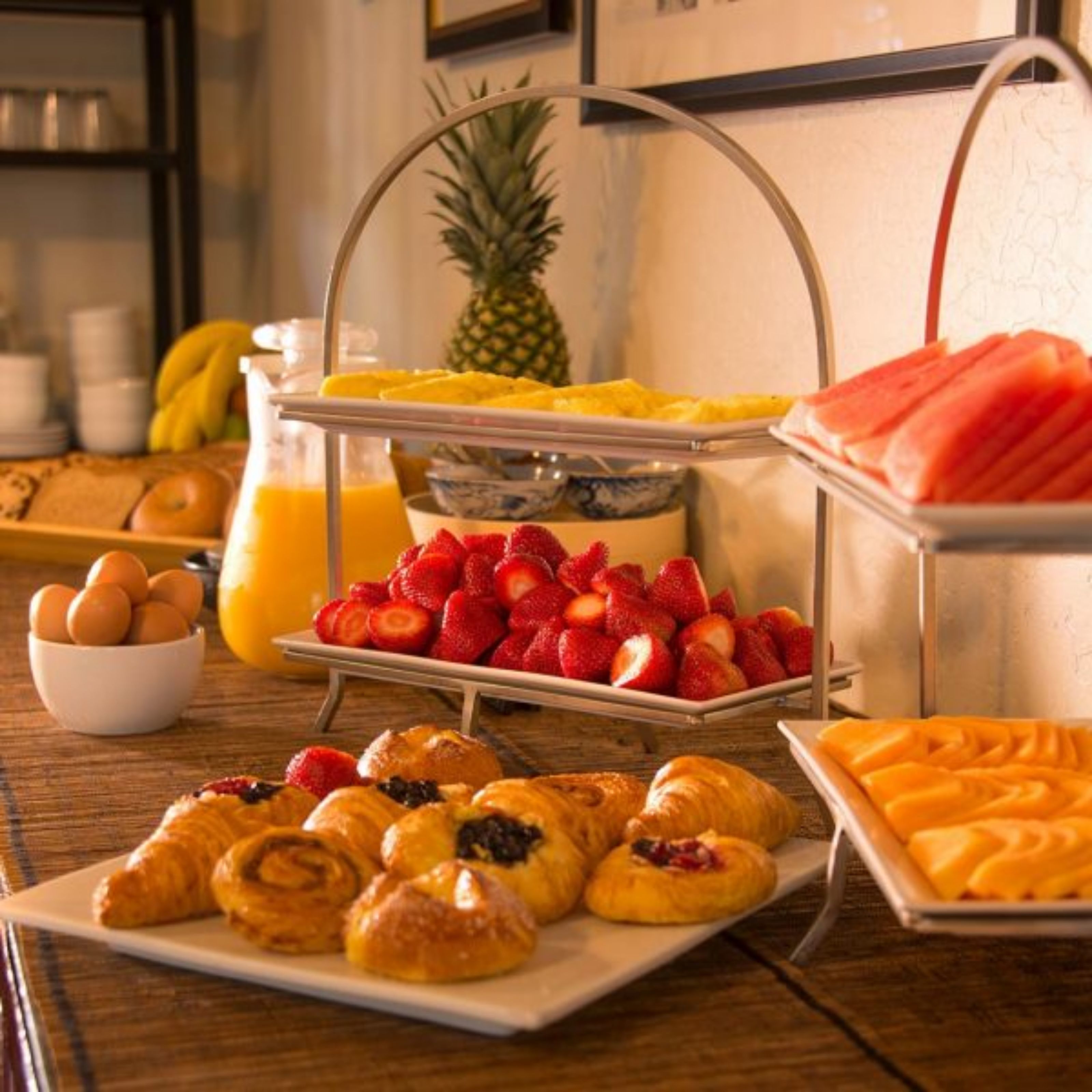 Ein Frühstücksbuffet mit verschiedenen Früchten, Gebäck und einer Ananas.