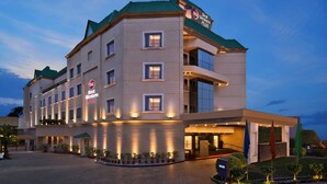 Een hotel met meerdere verdiepingen, met een modern design, een opvallende entree en een goed verlichte gevel.