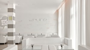 A modern, minimalist hotel lobby with white furniture and a large wall with handwritten notes. - The Pure, a Member of Design Hotels (Frankfurt)