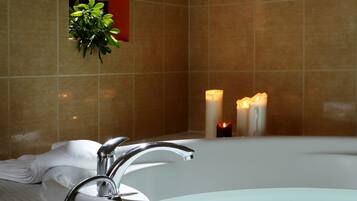 A bathroom with a bathtub, a towel rack, and a small potted plant.