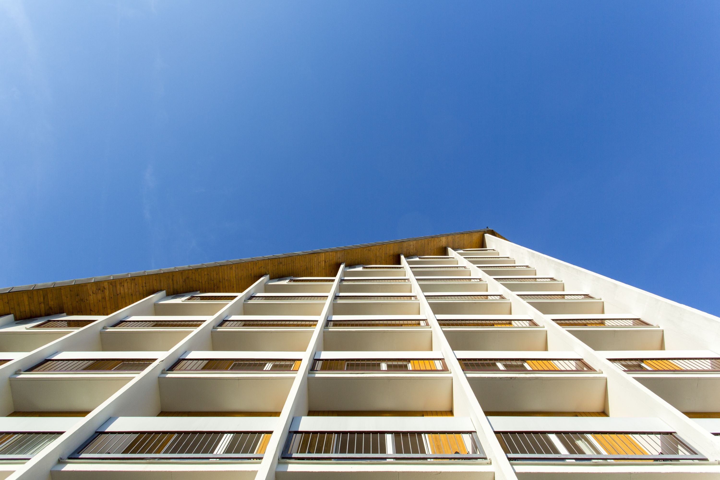 Un edificio moderno con una fachada de balcones y grandes ventanales.