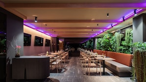 A restaurant with a long counter, multiple tables, and a seating area with a sofa. - OREA Resort Sklář Harrachov (Harrachov)