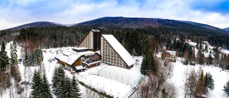 A resort with a large building featuring a sloped roof and a smaller annex.