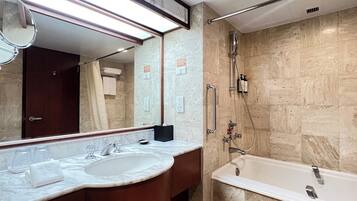 Une salle de bain moderne avec un lavabo en marbre, un grand miroir, une baignoire et une douche équipée d’un pommeau de douche à main.