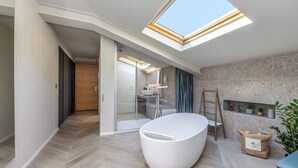 A modern bathroom with a skylight, a freestanding bathtub, and a shower area. - Hotel Val di Sogno (Malcesine)