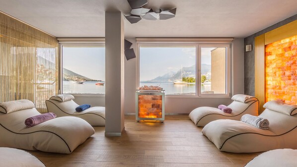 A spa room with two massage chairs, a saltwater pool, and a view of the sea. - Hotel Val di Sogno (Malcesine)