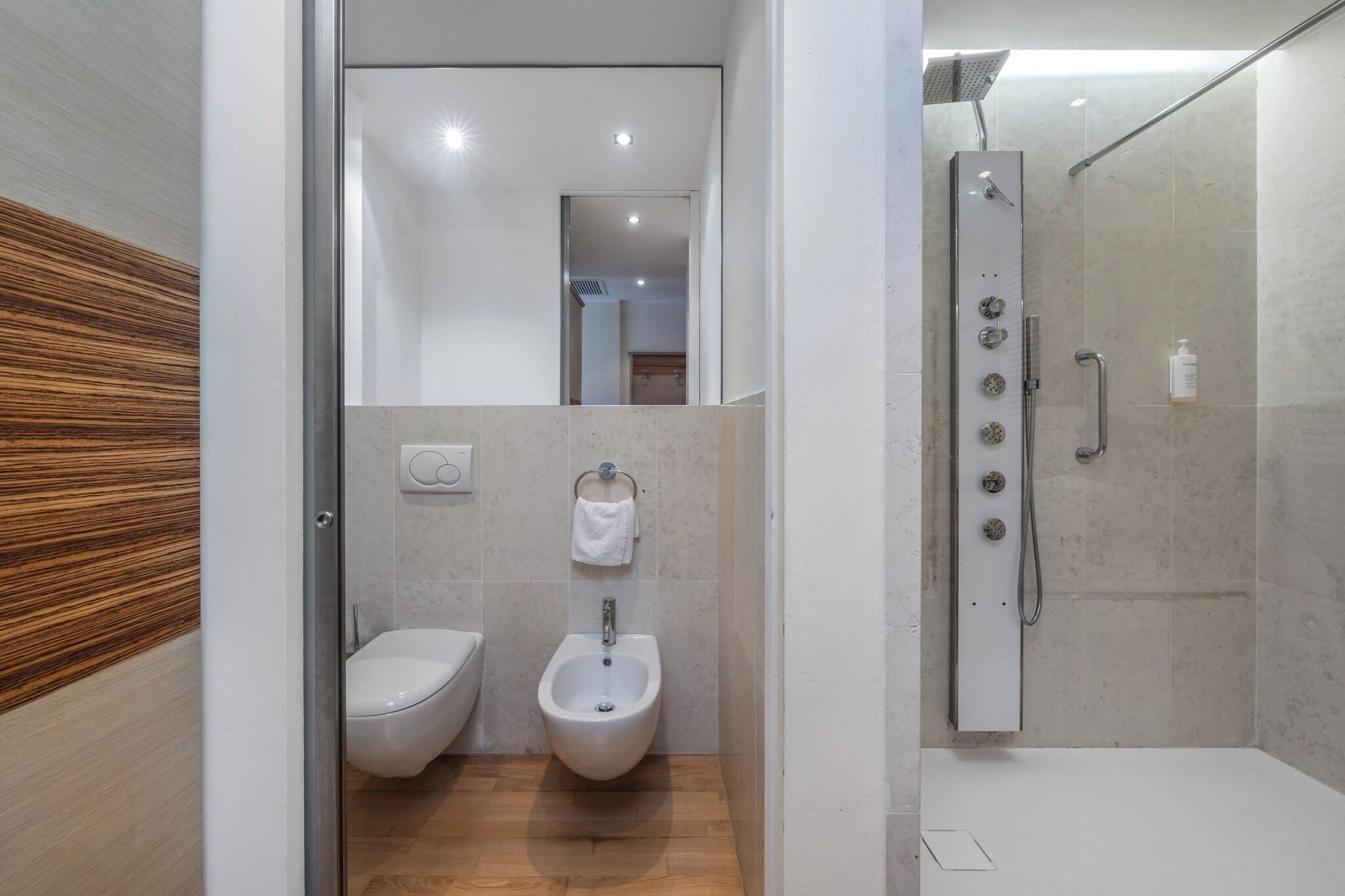 Un baño moderno con un bidé, inodoro y ducha.