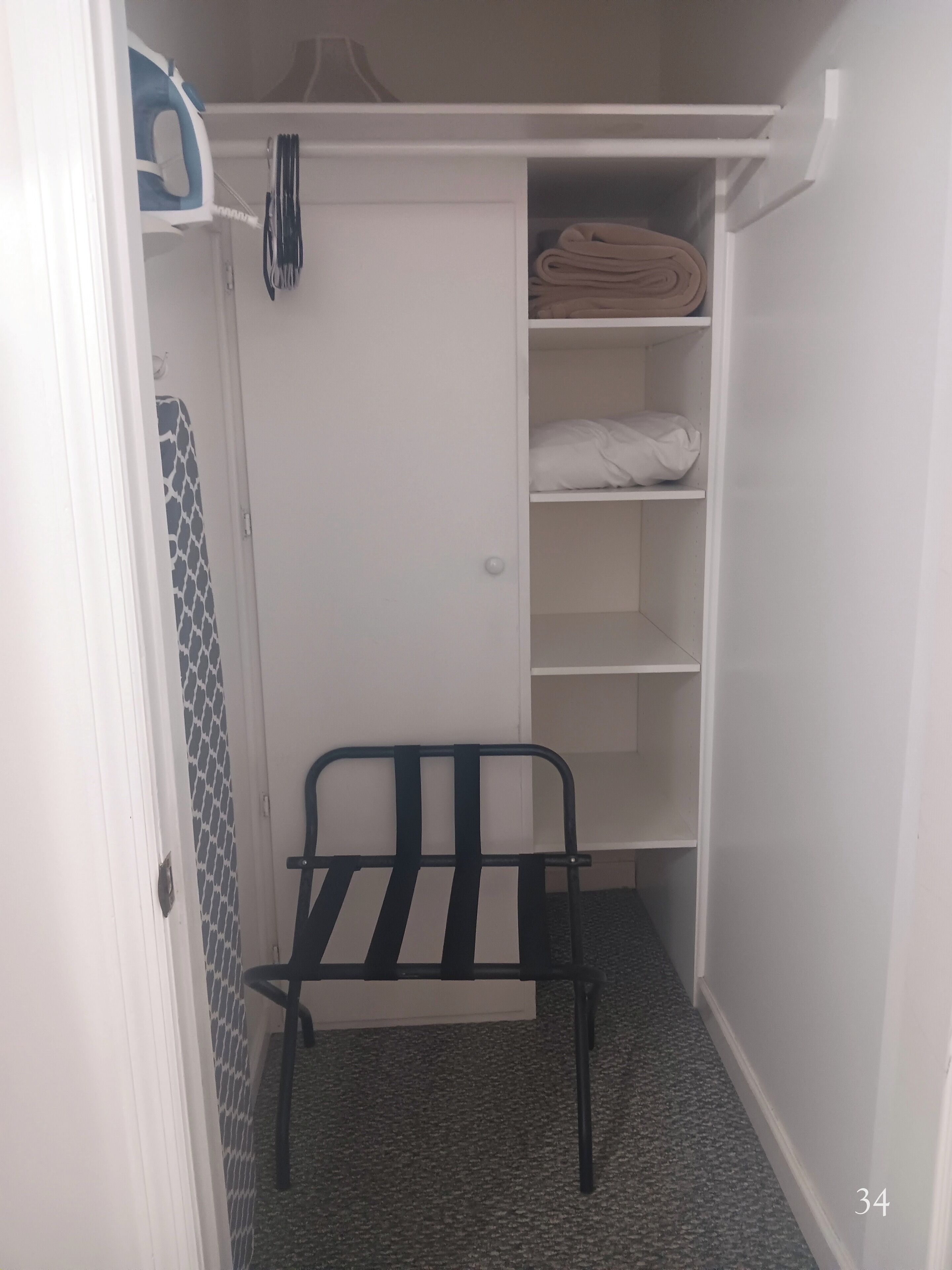 A closet with shelves and a bench.