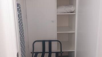 A closet with shelves and a bench.