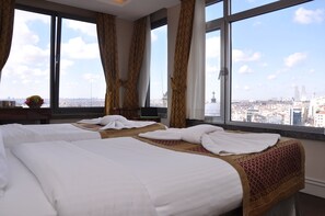 A hotel room with two beds, large windows with curtains, and a city view. - Taksim Star Hotel (Istanbul)
