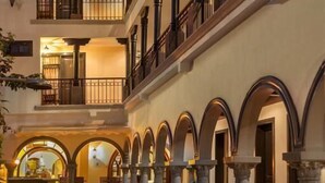 Pátio com vários níveis, piscina, colunas e áreas de estar ao ar livre.