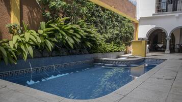 Alberca al aire libre y camastros