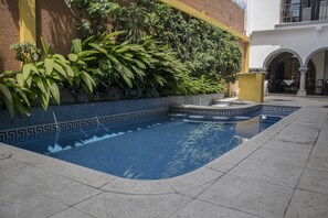 Una piscina al aire libre, sillones reclinables de piscina