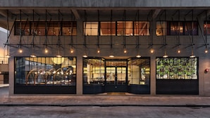 A modern building with large windows, a ground floor with a bar area, and a second floor with a staircase.