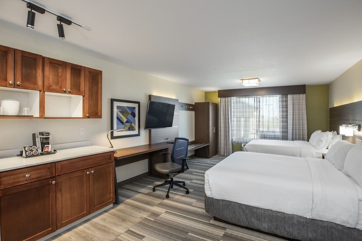 Une chambre d’hôtel équipée d’un lit, d’un bureau, d’une chaise et d’un téléviseur.