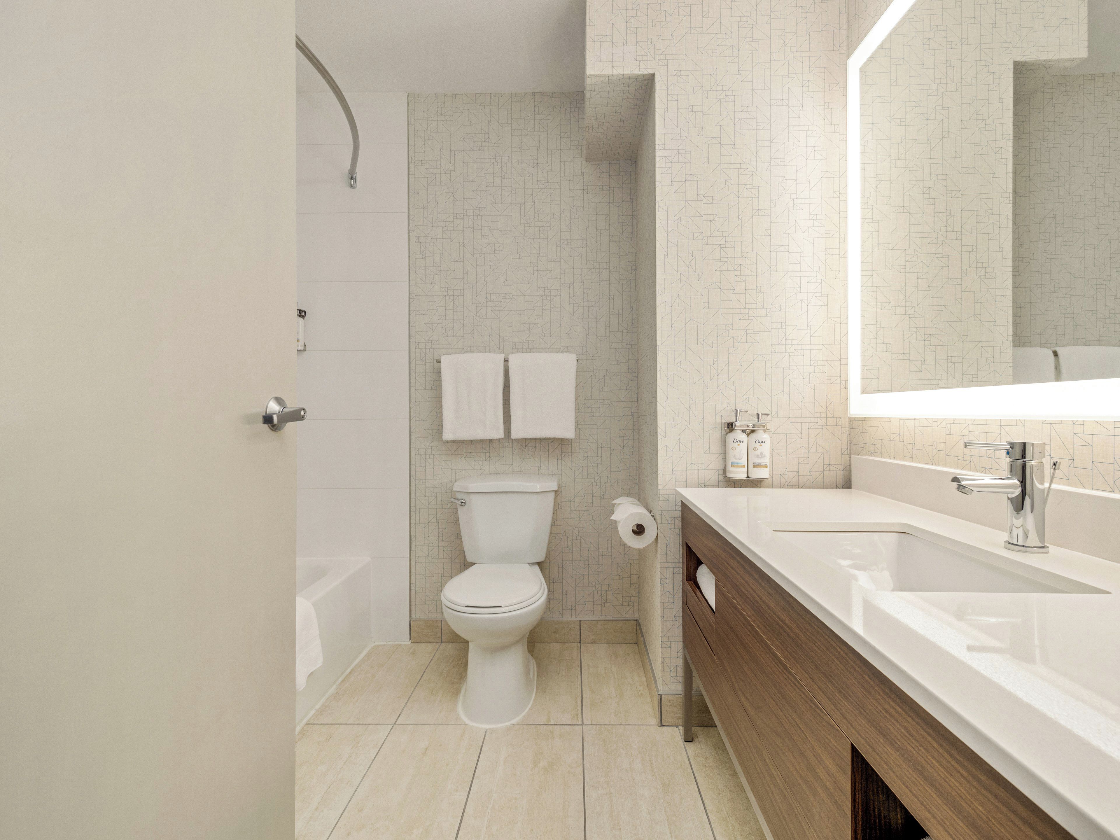 A modern bathroom with a toilet, sink, and shower.