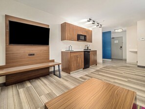 Een moderne keuken met houten kastjes, een ingebouwde magnetron en een zwarte vaatwasser.