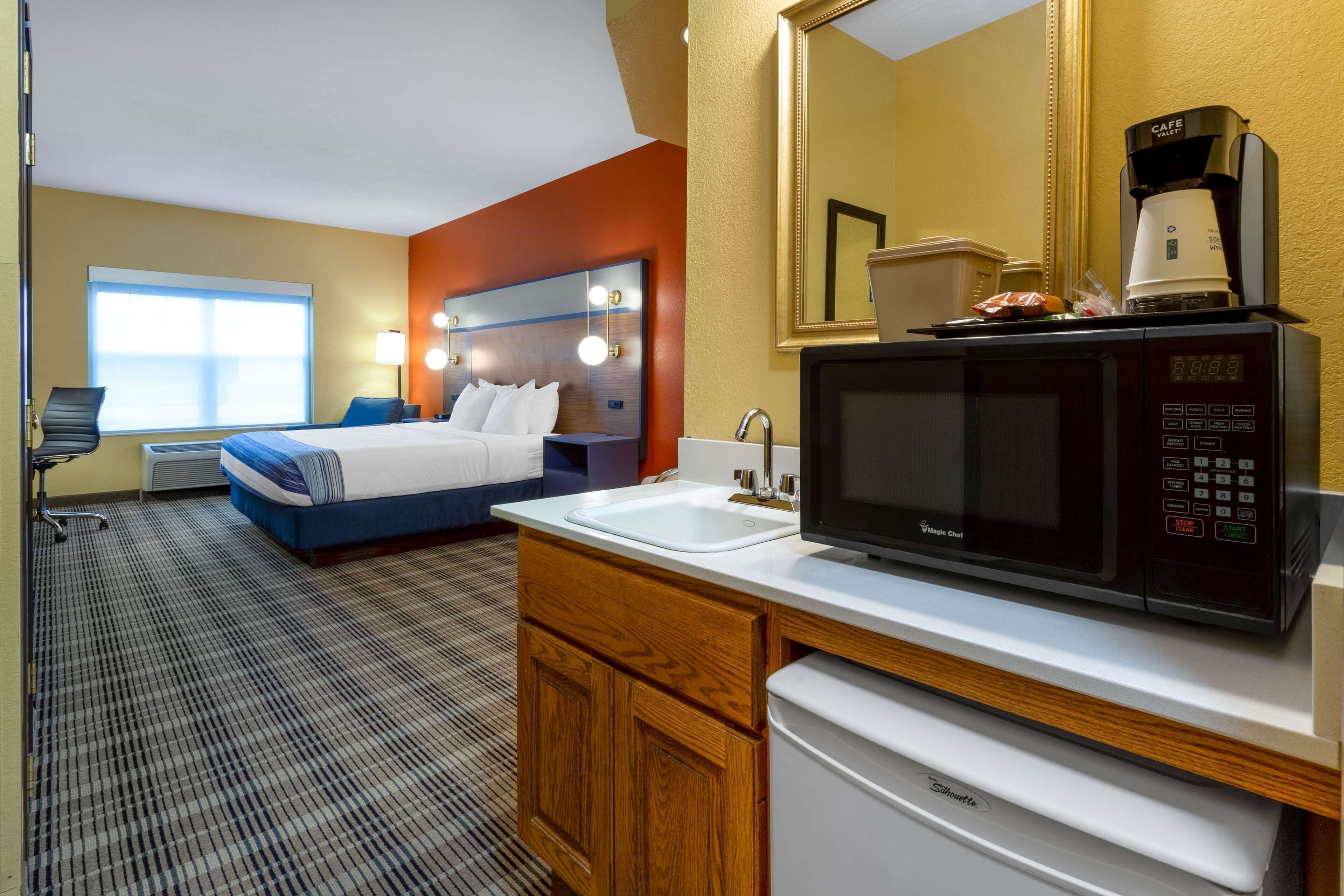 Une chambre d’hôtel équipée d’un lit, d’un lavabo, d’un four à micro-ondes et d’une machine à café.